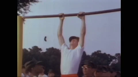 1960s: Recruit struggles to perform pull ups. Soldiers exercise with rifles in Stock Footage 160353709