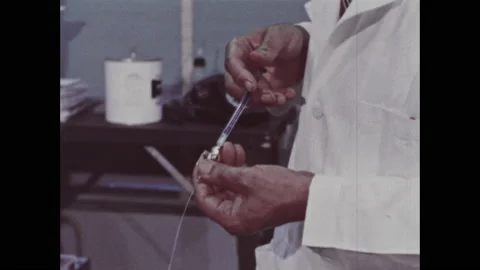 1960s: Researcher holds needle. Polygraph records blood pressure reading. Stock Footage 137835845