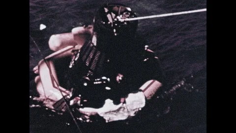 1960s: Rocket capsule is floating on water and pulled by crane. Men on deck of 스톡 동영상 101403945