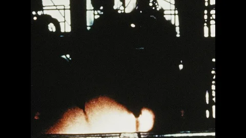 1960s: Rocket engine blasting. Close up of engine. Fuel tanks in hangar. Man Stock Footage 100643021