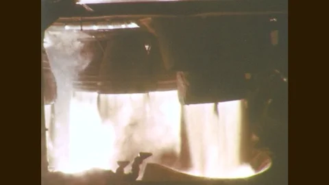 1960s: Rocket engines fire. Rocket booster engine fires from launch pad. Stock Footage 77051763