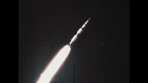 1960s: Rocket flies into space. Man rides bicycle up to office building. People Vídeos de archivo 106411608