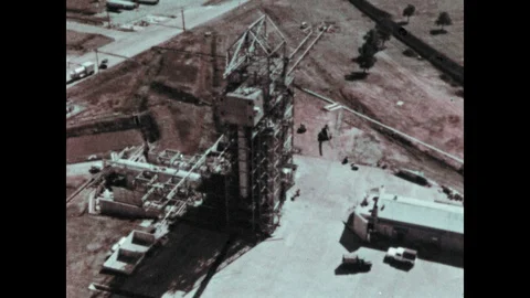 1960s: Rocket launch site. Factory building. Large red rocket launch site in Vídeos de archivo 104881389
