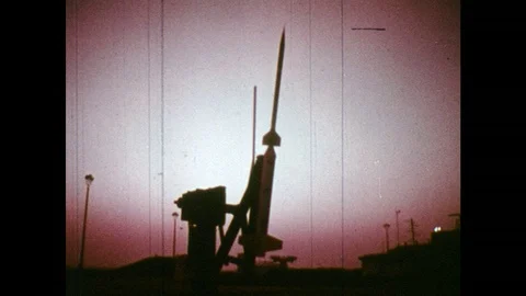 1960s: Rocket on launchpad / Dissolve, workers building rocket / Men attach nose Stock Footage