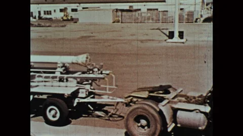 1960s: Rocket is pulled by a truck on a trailer. Crane moves rocket on trailer 스톡 동영상 124817846