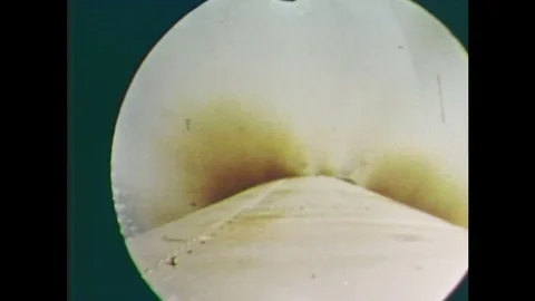 1960s: Rocket sheds engine module in space, earth below. Module breaks apart. Stockbeeldmateriaal 84905603