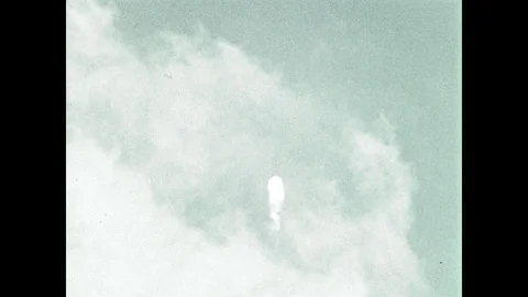 1960s: Saturn C1 rocket flies through clouds in the atmosphere until almost it Stock Footage 101403784