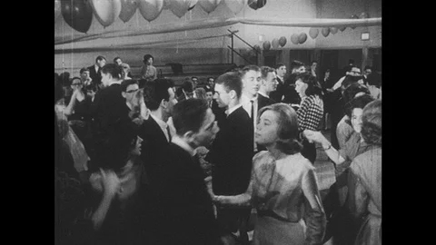 1960s: School dance.  Couples dance.  Group of boys smiles and talks. Stock Footage 88155518