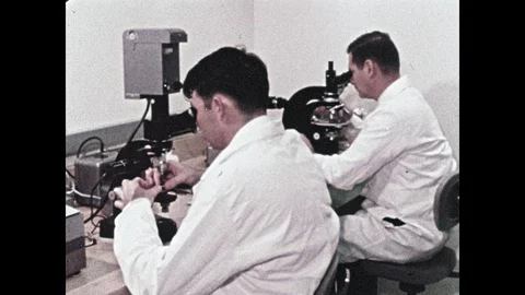 1960s: Scientists look through microscope. Microscopic objects. Rocks. Stock Footage 100302261