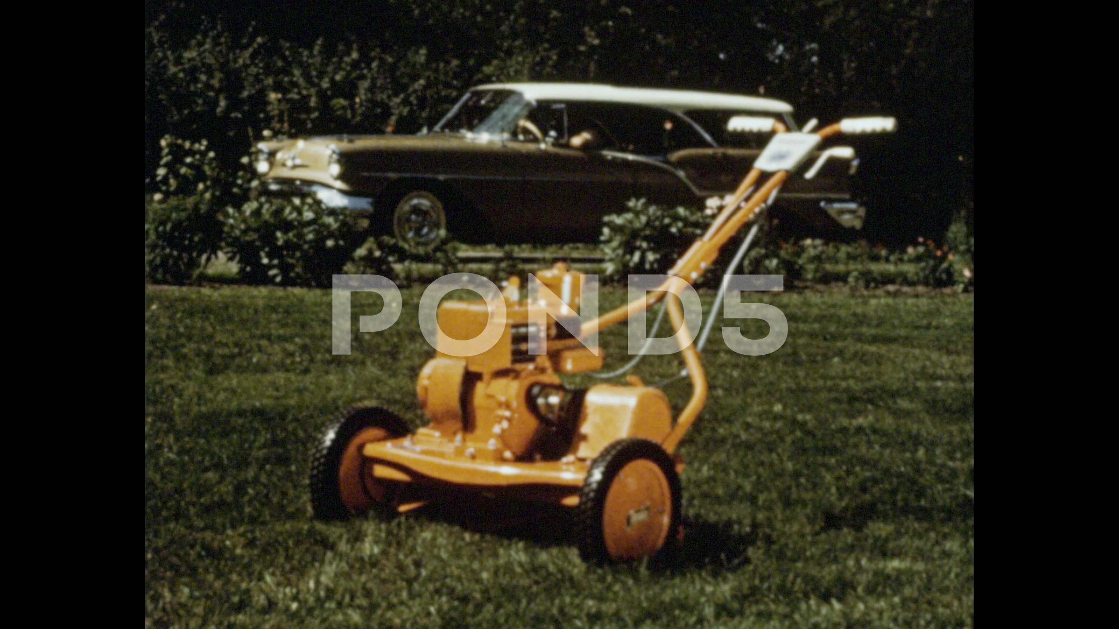 1960s: A shiny yellow lawnmower on a gra, Stock Video