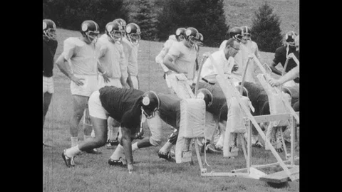 1960s: In slow-motion, players lunge into tackle on wooden frame impact Stock Footage