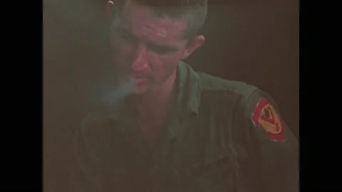 1960s: Soldier on patrol boat lights cigarette. Soldier smokes. Soldiers eats Stock Footage