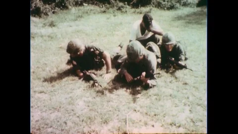 1960s: Soldiers on ground, soldiers stand and walk. Stock Footage