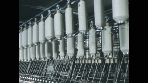 1960s: Spools of thread spin in industrial textile mill. Woman inserts thread Stock Footage 211281634