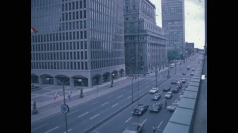 1960s: street in city, traffic on road, flags outside building, queens guards Stock Footage