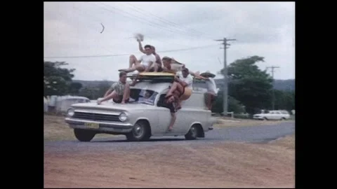 1960s Surfing - many surfers ride on top of a van. Stock Footage