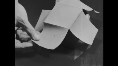 1960s: Thin paper coating of the 3x3 cube model is removed, unfolded and laid Stock Footage 118178042