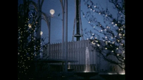 1960s: Tilting view up Space Needle. Boy and girl get up from bench, run off Video stock 88788092