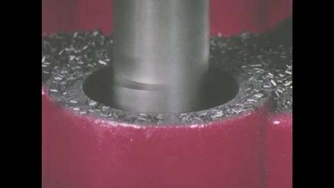 1960s: Tool bores hole into object. Tool descends on object Video stock 78580105