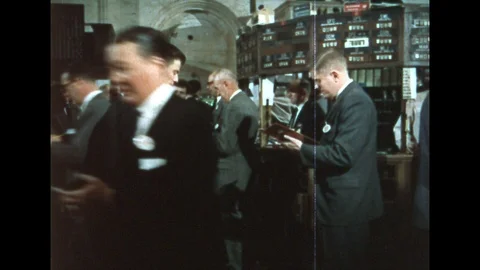 1960s: Traders buy and sell on floor of the stock exchange. Man places paper Stock Footage