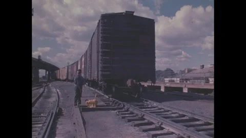 1960s: Train moving in rail yard, men working by tracks. Stock Footage 277674957