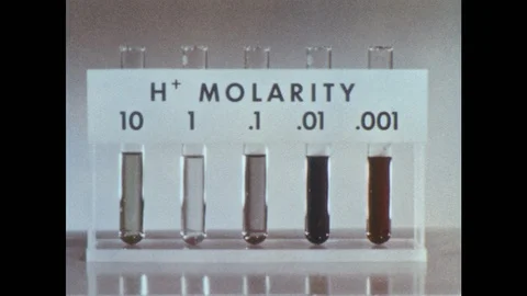 1960s: Tray of test tubes is labelled "H+ MOLARITY."  Man uses dropper to put Stock Footage 97010997