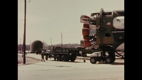 1960s: Truck pulling rocket part. View of open hangar. Aerial view of hangar on 스톡 동영상 100643124