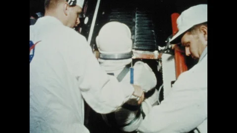 1960s: Two astronauts are assisted into cockpit of rocket. Man close doors of 動画素材 101665304
