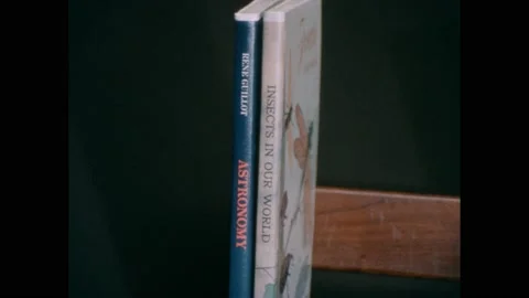 1960s: Two books sit on left side bookshelf. Five books sit on right side Stock Footage 238835170
