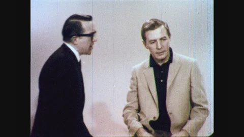 1960s: Two men sit on stool, talk. Man s... | Stock Video | Pond5