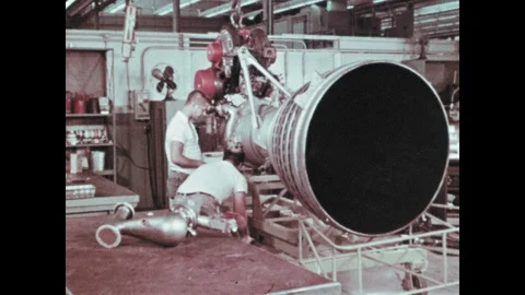 1960s: Two men work on rocket engine. Rocket engines being build in warehouse Stock Footage 104881291