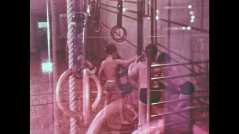 1960s: UNITED STATES: children pull out climbing bars in gym. Children arrange Stock Footage