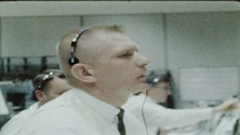 1960s: UNITED STATES: man pulls face during thoughts. Man speaks through headset Stock Footage 89580957