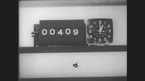 1960s: UNITED STATES: numbers on counter by clock timer. Hand adjusts switch Stock Footage