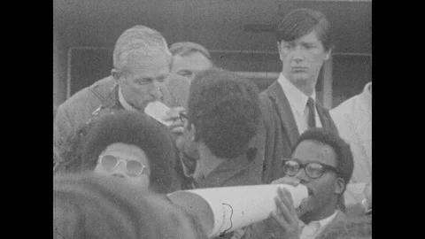 1960s: UNITED STATES: students in protest. Man photographs strike action. Skull Stock Footage