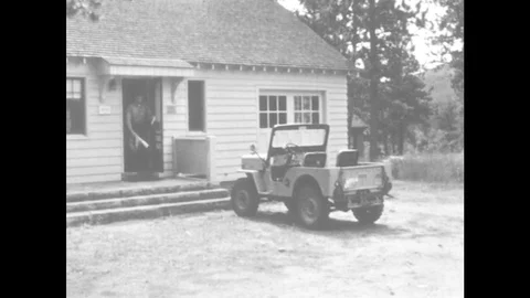 1960s: UNITED STATES: van parked outside house. Ranger gets into vehicle. Man Stock Footage