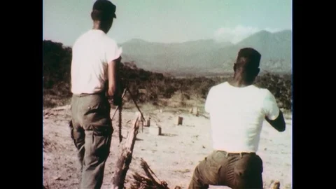 1960s: View from behind, soldiers fire guns / Close up of soldier / Low angle Stock Footage