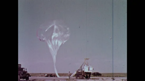 1960s: Weather balloon inflates and lifts into air with equipment attached being Stock Footage