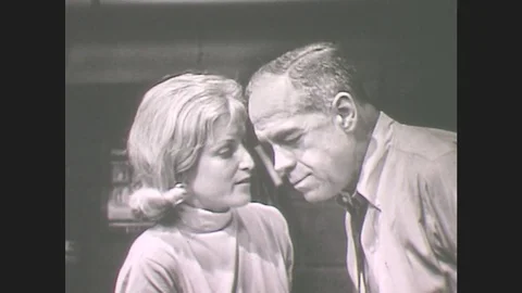 1960s: Woman Stands Close To Man, Smiling, Talking, Man Smiles, Woman Sits. Stock Footage