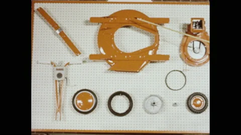 1960s: A wooden pointer points to various lawnmower parts displayed on a white Stock Footage 151047517