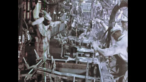 1960s: Workers in factory, men using tools on assembly line. Man connects parts Video stock 103558675