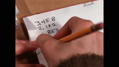 1960s: written calculation on paper. Hand holds pencil. Hands erases pencil Stock Footage 219965717
