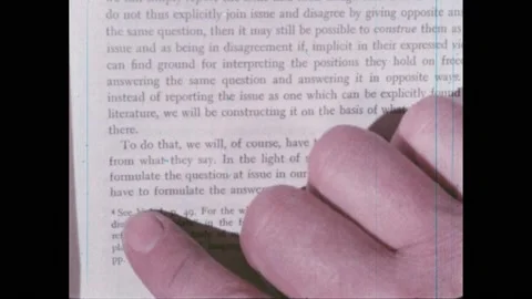 1960s:Finger points at reference number on page in book. Men sit at desk, look Stock Footage 220430709