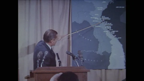 1960s:Press take notes as McNamara points to map of Vietnam. Soldiers stand in Stock Footage 139284437
