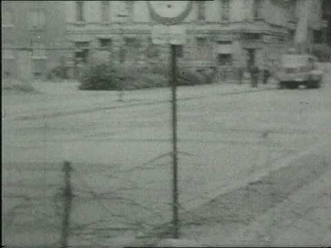 1961 THE BERLIN WALL: armed uniformed guards, sneaking across border, stone wall Stock Footage 77872199