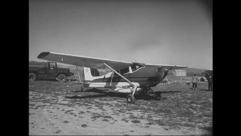 1961 - A crop-duster sprays over an Iranian field of crops. Stock Footage 122529385
