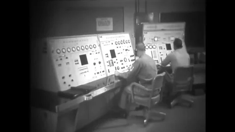 1961 - Flight controllers at workstations press buttons and turn knobs in an 스톡 동영상 79447905