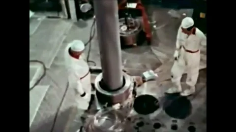 1961 - A moderating cask is moved over an encapsulating assembly at a nuclear Stock Footage 103270278