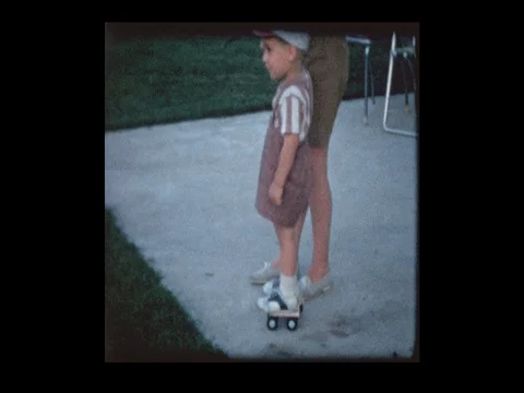 1961 Mother teaches Little boy how to skate on vintage Roller Skates Stock Footage