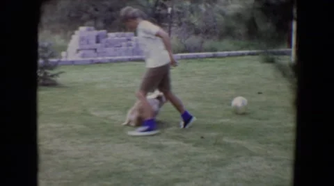 1961: A Small Boy and Cute Dog Playing with Rubber Ball in Yard Toledo Vidéo 67580597